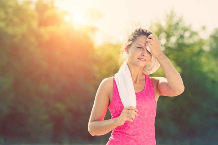 female runner wiping sweat after a running workout